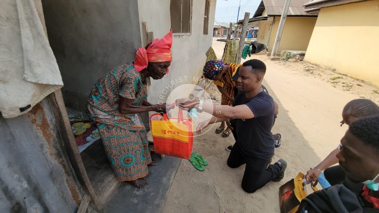 Handing a gift bag to an elderly mother at her door.