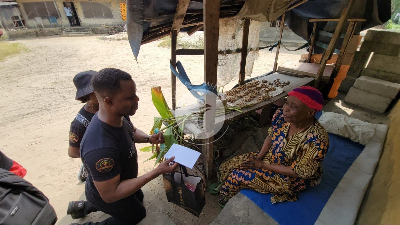 Giving a gift to an elderly mother at her stall.